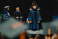 A Ph.D. graduate is hooded.