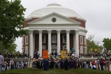 School banners are carried down the Rotunda steps, with students behind them.