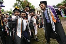 A group of students poses while walking in the Lawn procession